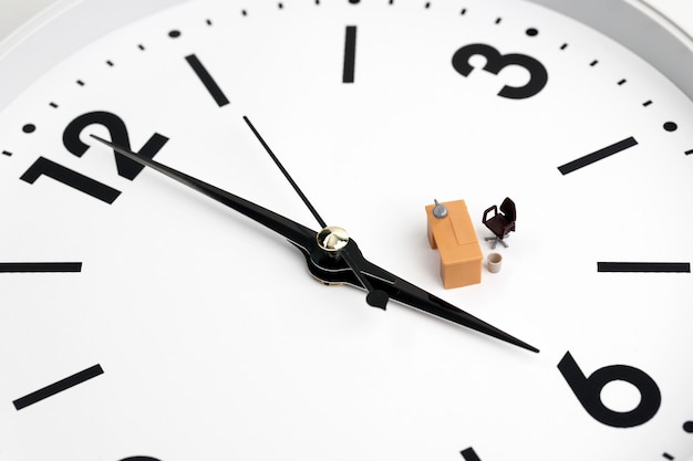 Miniature table and chair on clock background