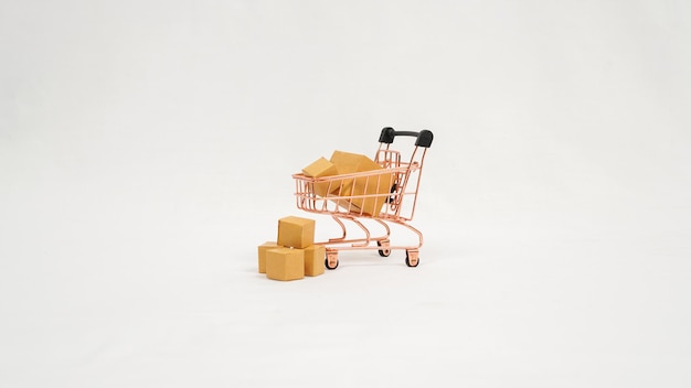 Miniature trolley and stack of brown boxes isolated on white background