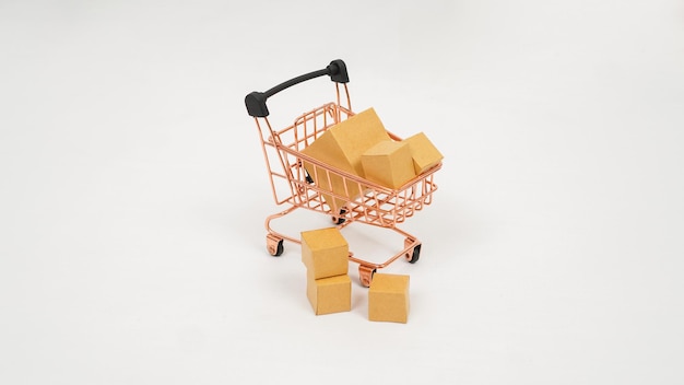 Miniature trolley and stack of brown boxes isolated on white background