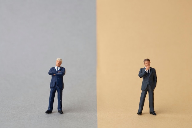 Photo miniature two businessmen stand on opposite sides