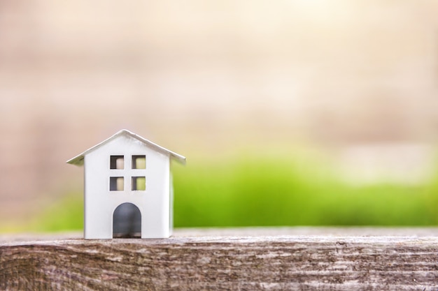 Miniature white toy model house in wooden background