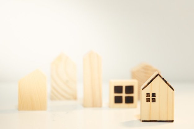 Foto casa in legno in miniatura sul tavolo di legno. concetto finanziario del bene immobile di ipoteca della casa e di investimento immobiliare.