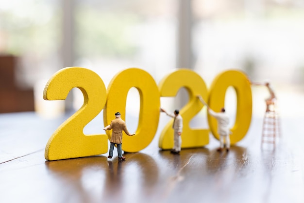 Фото Миниатюрная рабочая команда нарисовала номер 2020 счастливого нового года 2019 концепция