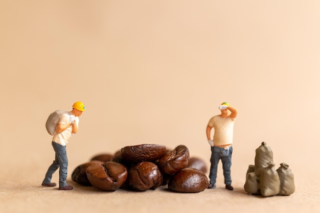 Miniature worker team working with coffee beans