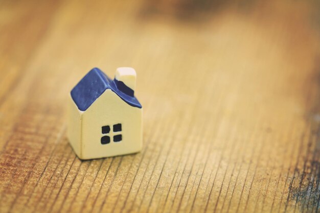 Miniature yellow toy house on a wooden table