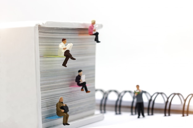 Miniatures people reading with book, education or business concept.