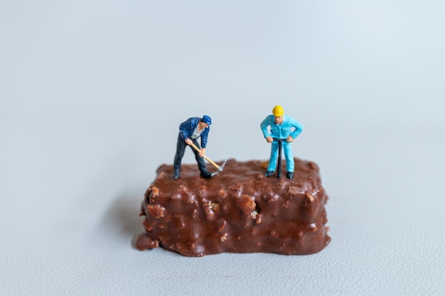 Miniatuur Een medewerker maakt chocoladerepen op een grijze achtergrond World Chocolate Day Concept