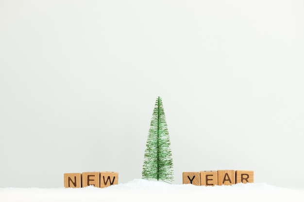 Miniatuur kerstboom in een besneeuwd landschap op wit