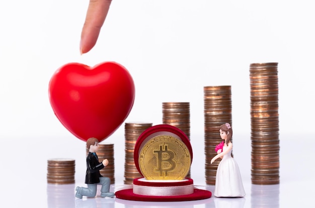 Miniatuur kleine pop van paarliefhebbers stellen voor huwelijk voor met romantisch valentijnsmoment met achtergrond van stapelmunt als besparing in bitcoin cryptocurrency metafoor concept handel liefdesgeld