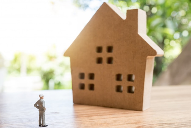 Miniatuur man met houten huis