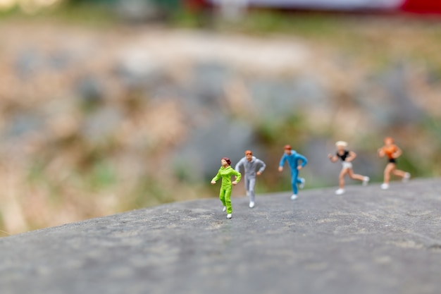 Foto miniatuur mensen die op de rots lopen
