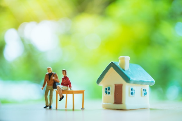Foto miniatuur mensen, man en vrouw blijven voor huis, gebruik voor zakelijke en relatie-concept
