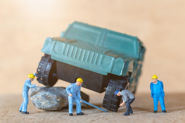 Foto miniatuur mensen mechanica repareren een militair voertuig auto service concept