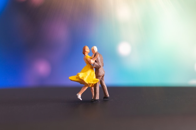 Miniatuur mensen, paar dansen met kleurrijke achtergrond