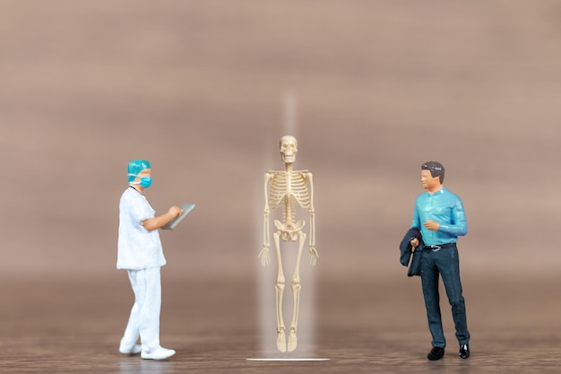 Miniatuur mensen patiënten worden besproken door een orthopedisch arts