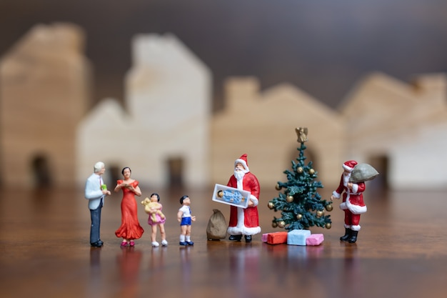 Miniatuur mensen: santa claus en gelukkige familie