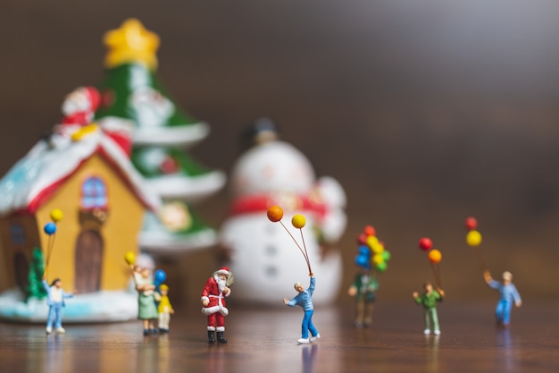 Miniatuur mensen: Santa Claus en kinderen houden ballon