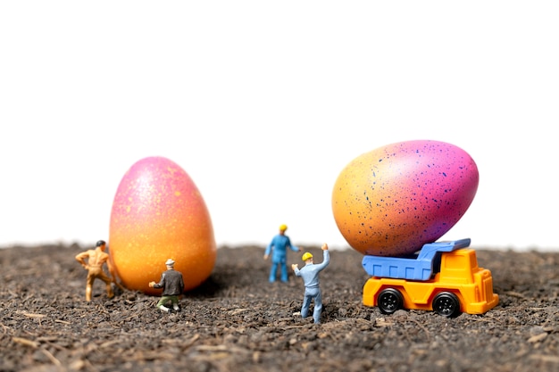 Miniatuur mensen werken met Pasen-eieren voor Pasen