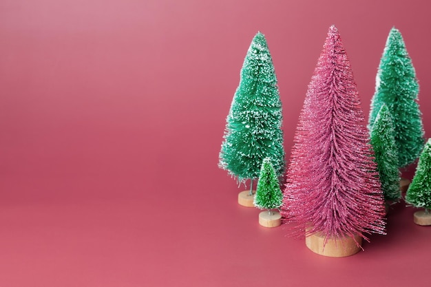 Miniatuur set model winter dennenboom met sneeuw en glanzend is rekwisieten decoratie voor het creëren van sfeer Kerstmis Kerstdecor kerstboom op roze achtergrond Kopieer ruimte