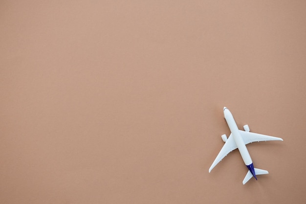 Foto miniatuur speelgoed vliegtuig op beige achtergrond zomer vakantie vliegreizen per vliegtuig concept