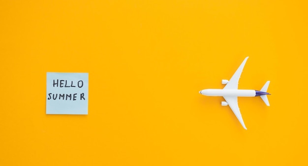 Miniatuur speelgoed vliegtuig op kleur achtergrond en woord hallo zomer Reis per vliegtuig