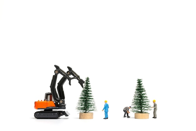 Miniatuurmensen, arbeider die kerstboom op witte achtergrond, Kerstmis en gelukkig Nieuwjaarconcept voorbereiden.