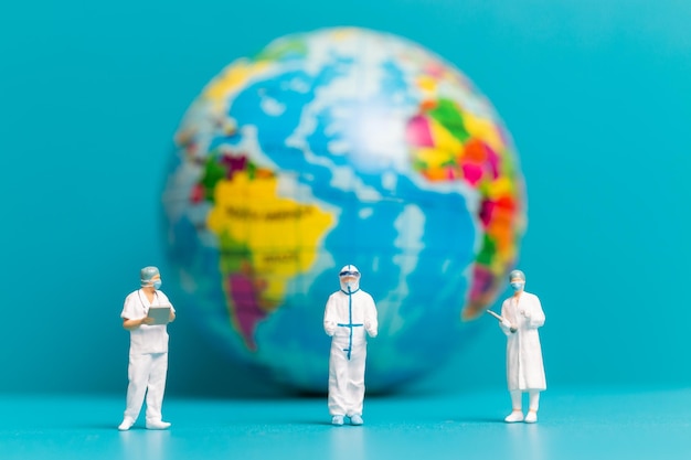 Miniatuurmensen Arts en verpleegster die wereldwijde gezondheidszorg controleren Wereldmilieudagconcept