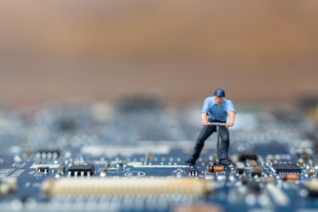 Miniatuurmensen die aan cpu-bord werken