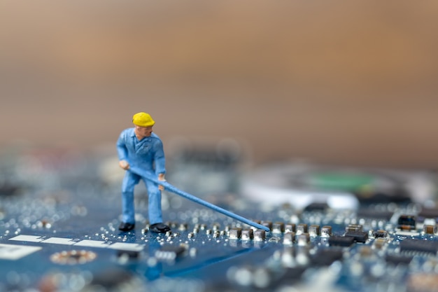 Miniatuurmensen die aan cpu-bord werken