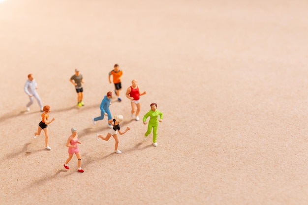 Miniatuurmensen die trainen terwijl ze in een groep op het strand rennen