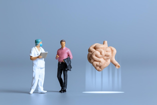 Miniatuurmensen Dokter die het concept van de menselijke dunne darm bestudeert en behandelt