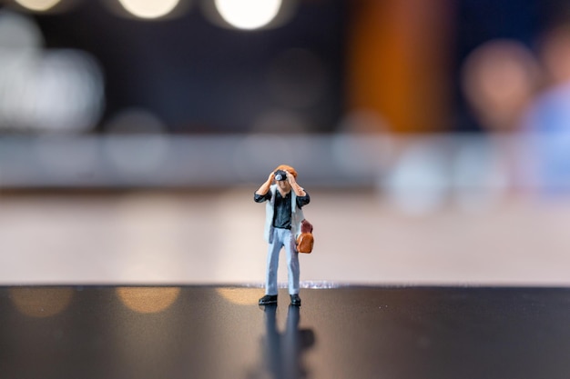 Foto miniatuurmensen fotografie met een camera en kopieer ruimte voor tekst