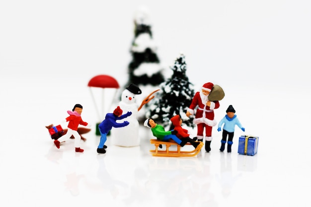 Miniatuurmensen: kinderen genieten met kerstman en sneeuwpop.