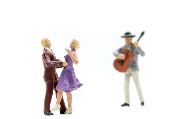 Foto miniatuurmensen koppel dansen met een gitarist die gitaar speelt