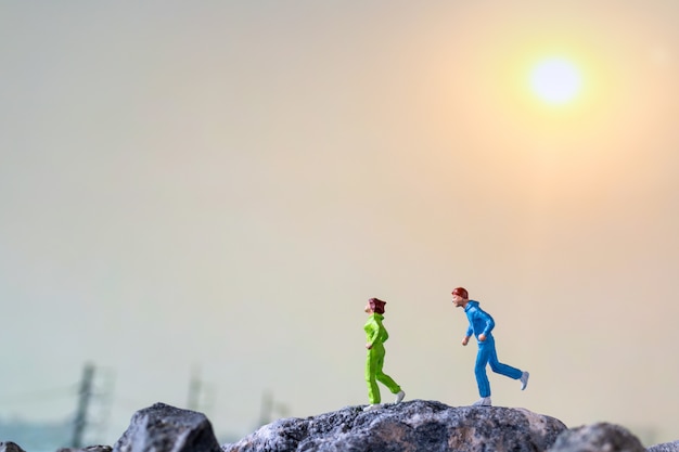 Miniatuurmensen: running on rock cliff, health and lifestyle concepts