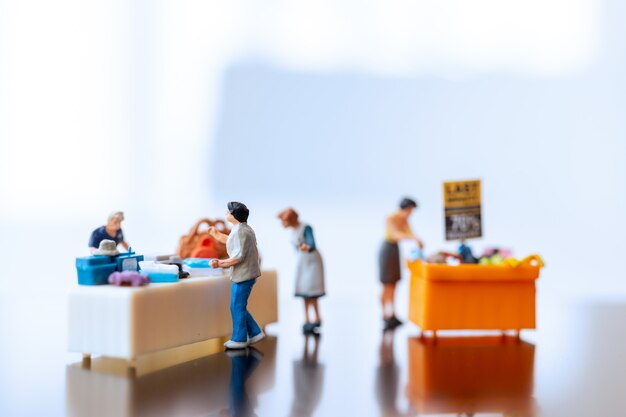 Miniatuurmensen, Shoppers met kortingsbakje voor het kopen van afgeprijsde artikelen