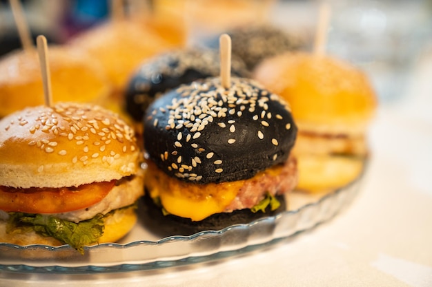 Miniburgers kleine cheeseburgers voor een vakantie van kinderen uit de jaren '39 Handige snacks voor de buffetcatering en bezorging van eten uit een café of restaurant