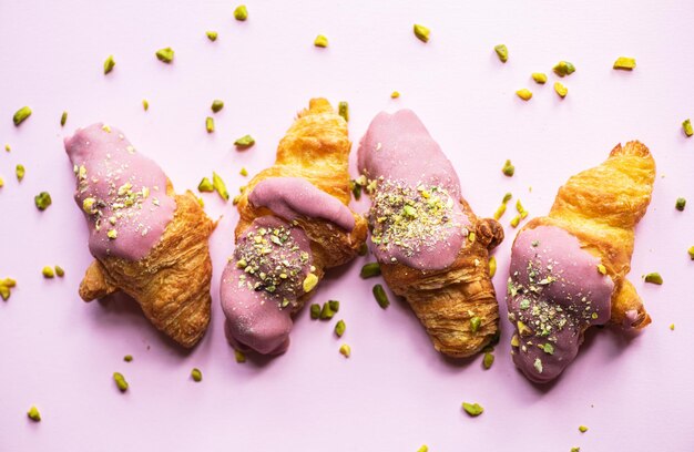 Minicroissants met ruby chocolade en pistachenoten op een roze achtergrond Bovenaanzicht