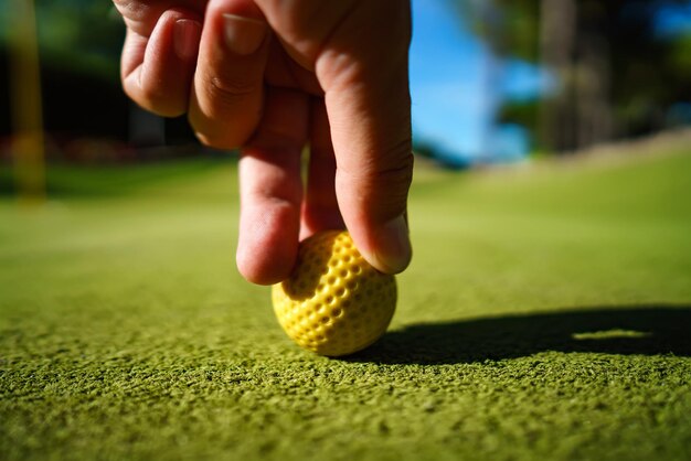 Foto minigolf gele bal op groen gras bij zonsondergang