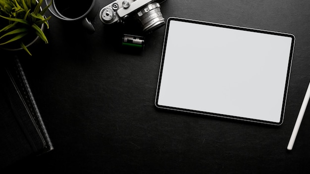 Minimaal zwart werktafelblad met filmcamera-accessoires kopieerruimte en tablet