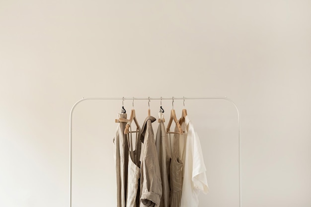 写真 最小限の美的ファッション服のコンセプトニュートラルベージュウォッシュドリネン女性ブラウスドレスと白い背景のハンガーのtシャツファッションブログウェブサイトソーシャルメディア