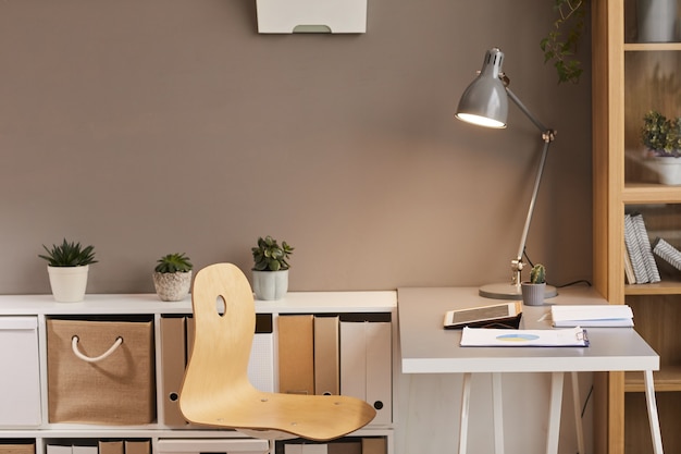 Photo minimal background image of cozy workplace lit by warm lighting from metal desk lamp, copy space