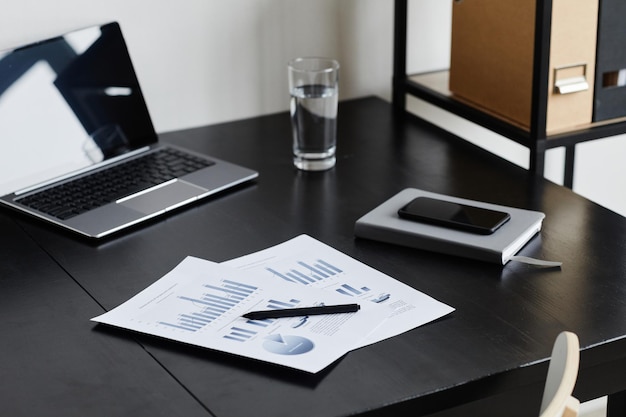 Photo minimal background image of documents at desk in home office in black copy space