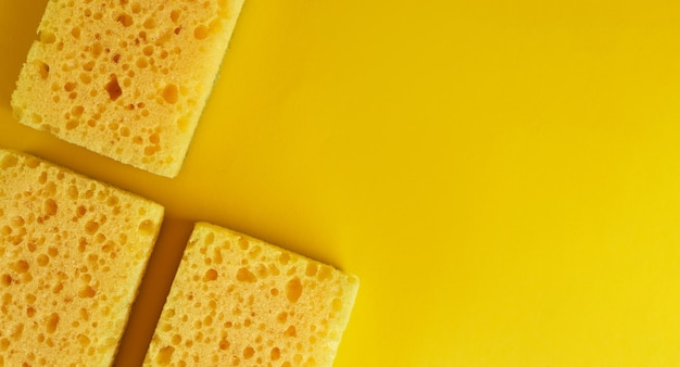 Minimal background with yellow sponges for washing dishes. Trendy yellow background