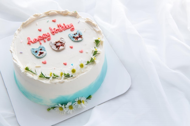최소한의 생일 케이크와 장식된 귀여운 얼굴 고양이와 작은 꽃