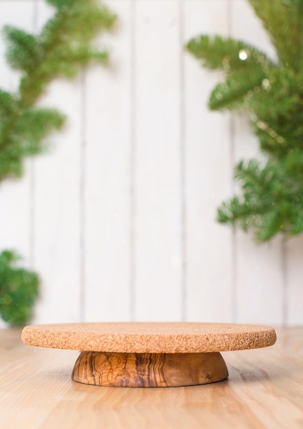 Minimal Christmas background with podium for a product presentation The pedestal is made of natural wood and cork with branches of the Christmas tree