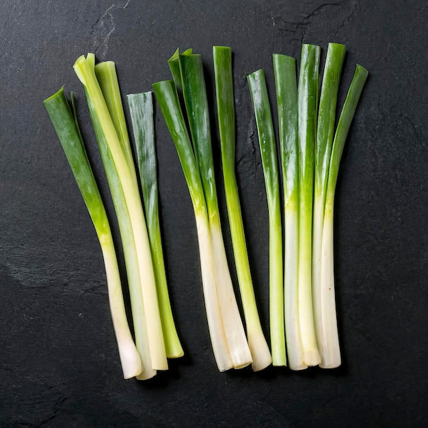 Minimal flat lay looking leeks view during slice progress over black