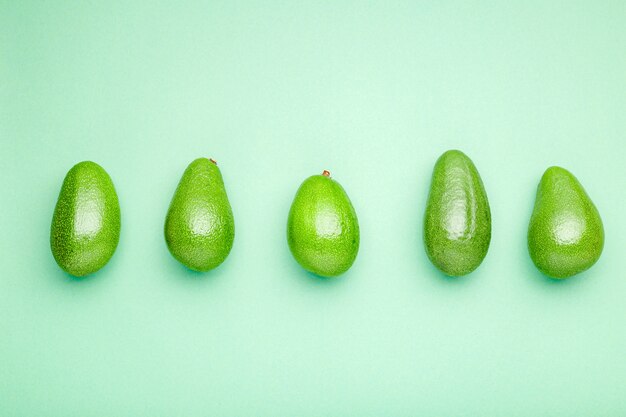 Minimal flat lay style avocado whole fruit on mint background