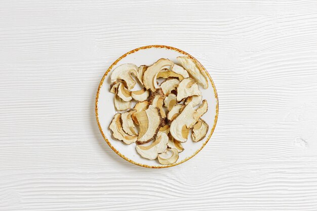 Minimal food background dried slices of porcini on plate dehydrated food boletus mushrooms on