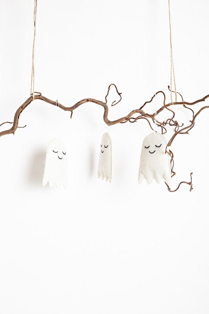 Minimal Halloween decoration hanging on tree branch isolated